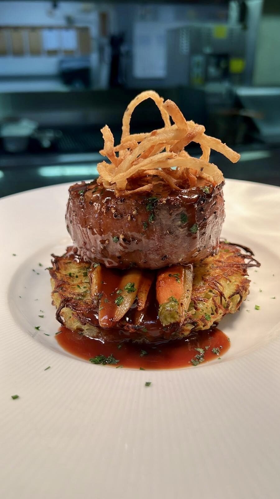 Plated filet mignon with vegetable rosti and carrots