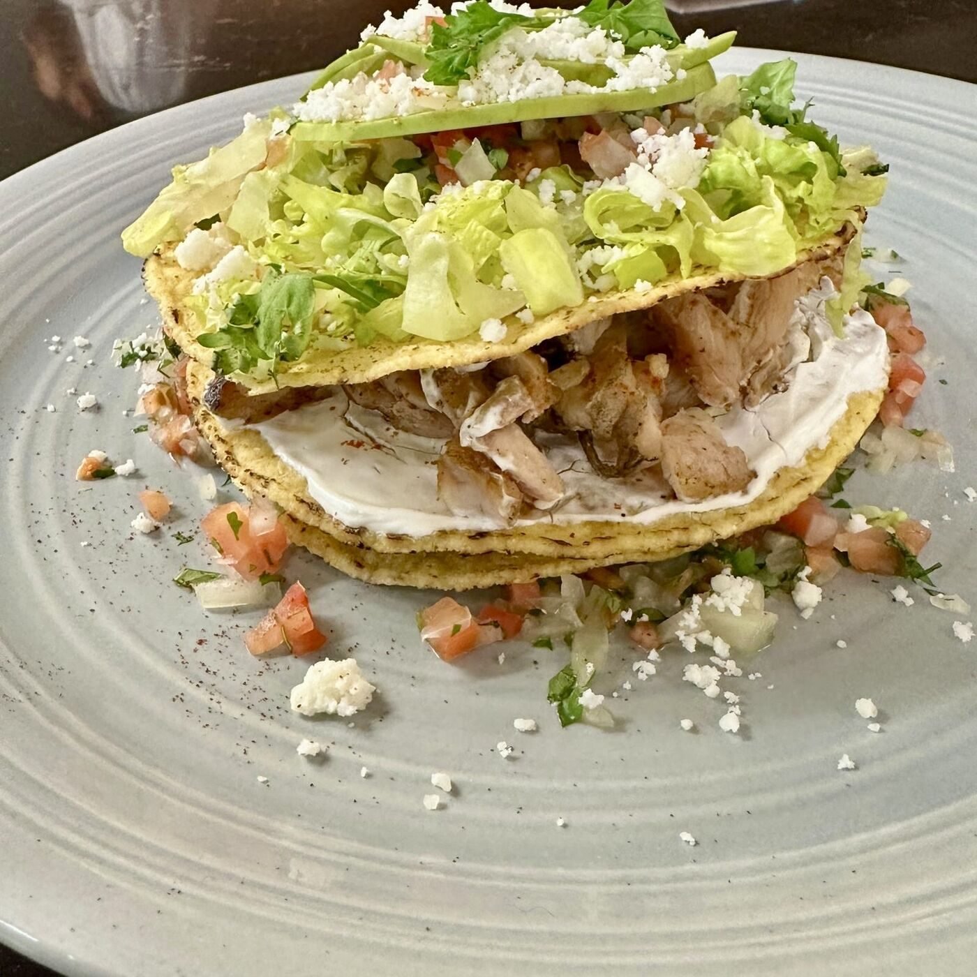 Crispy chicken tostada with lettuce, cotija, and avocado