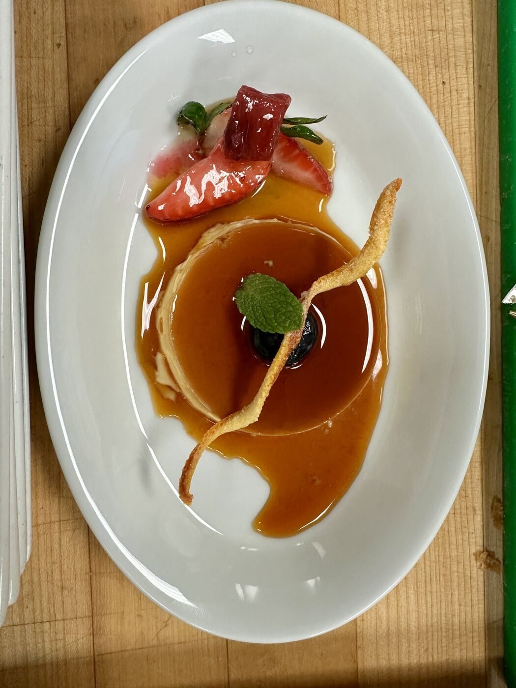 Caramel flan with strawberry and mint